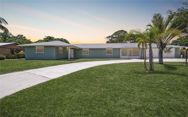 6001 Palm Dr, Fort Pierce, FL 34982 - ranch-style home with concrete driveway and a lawn