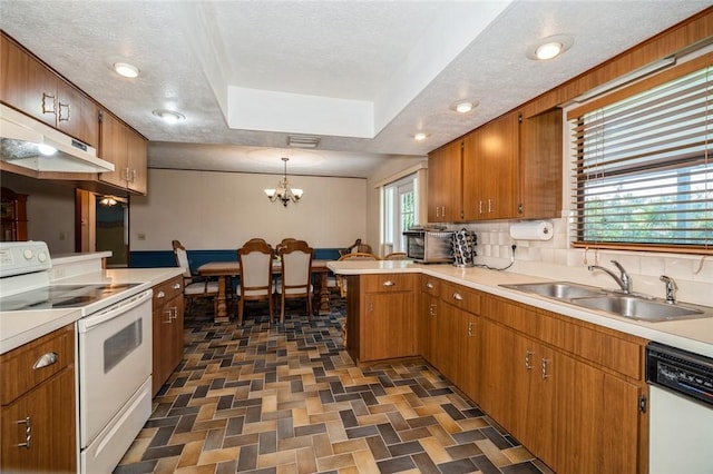 6001 Palm Dr, Fort Pierce, FL 34982 - kitchen featuring white appliances, a sink, a peninsula, a chandelier, and light countertops