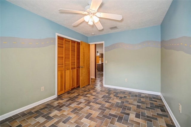 6001 Palm Dr, Fort Pierce, FL 34982 - unfurnished bedroom with a closet, baseboards, a textured ceiling, and ceiling fan