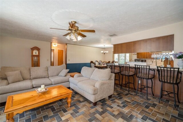 6001 Palm Dr, Fort Pierce, FL 34982 - living room featuring a chandelier, ceiling fan, and a textured ceiling