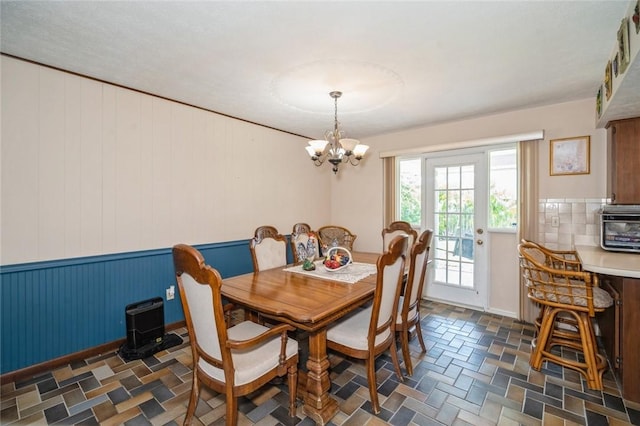 6001 Palm Dr, Fort Pierce, FL 34982 - dining room featuring a chandelier, wooden walls, and dark stone finish flooring