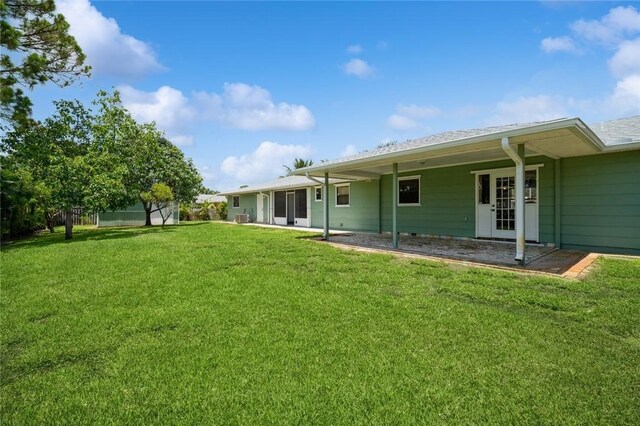 6001 Palm Dr, Fort Pierce, FL 34982 - rear view of property featuring a lawn