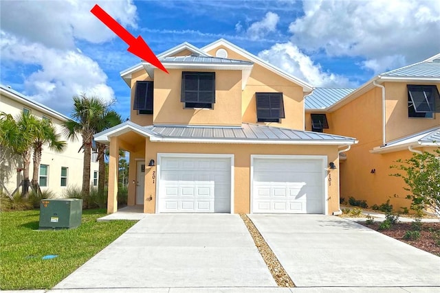 3951 Playa Del Sol Dr Unit 201, Rockledge, FL 32955 - view of front of property featuring stucco siding, metal roof, a standing seam roof, concrete driveway, and an attached garage