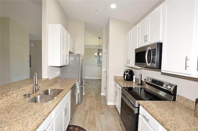 3951 Playa Del Sol Dr Unit 201, Rockledge, FL 32955 - kitchen with white cabinets, appliances with stainless steel finishes, a sink, and light stone counters