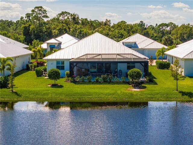 back of property featuring a yard, a water view, and a lanai