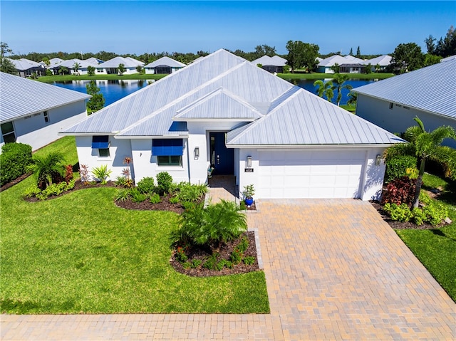 view of front facade featuring a water view, a front yard, and a garage