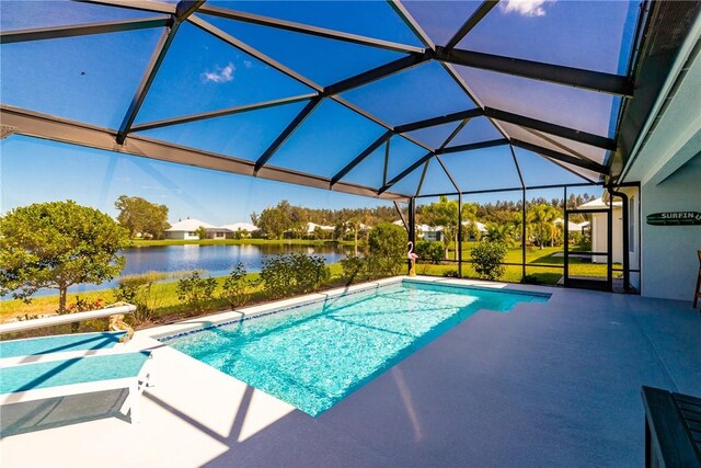 view of pool with glass enclosure, a water view, and a patio