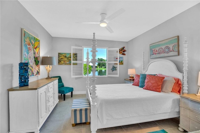 bedroom with dark tile patterned floors and ceiling fan