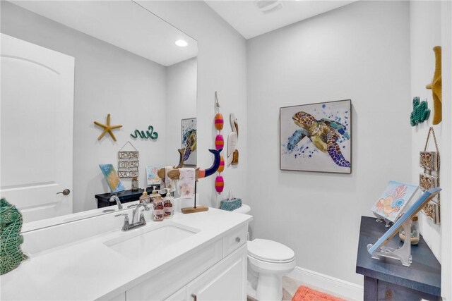 bathroom featuring tile patterned flooring, vanity, and toilet