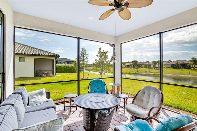 sunroom / solarium with ceiling fan, a water view, a residential view, and an outdoor living space