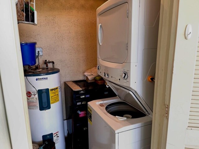 washroom with stacked washer and dryer and water heater