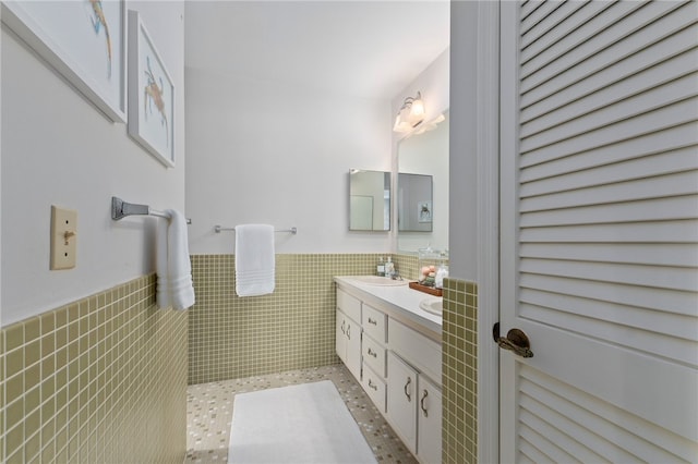 bathroom featuring vanity and tile walls