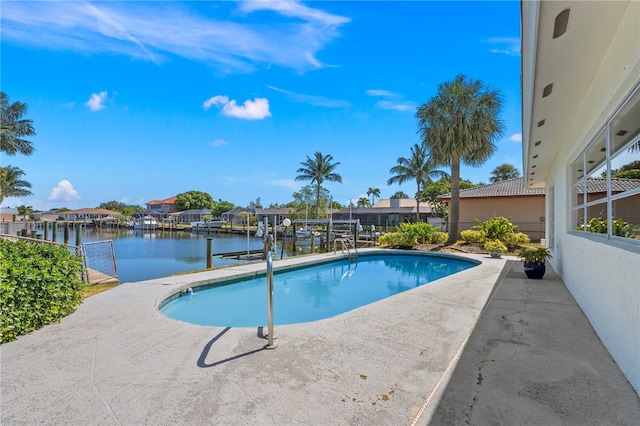 view of pool with a dock, a patio, and a water view