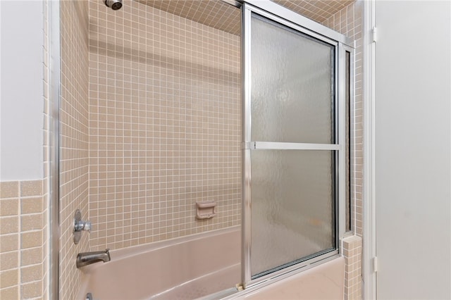 bathroom with bath / shower combo with glass door