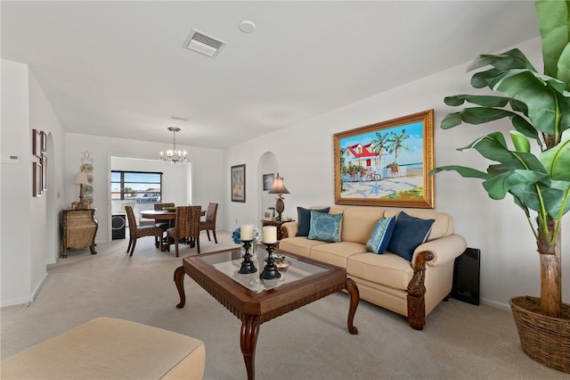 living room with an inviting chandelier and light carpet