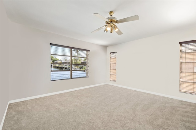 empty room with ceiling fan and light colored carpet