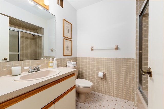 bathroom featuring vanity, tile patterned flooring, toilet, and tile walls