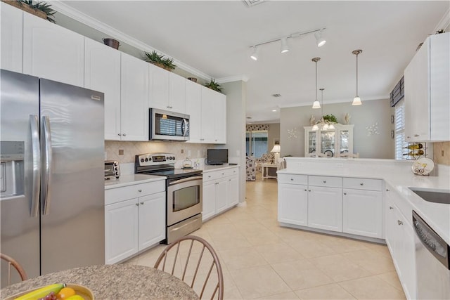 6341 Astor Pl, Vero Beach, FL 32966 - kitchen with appliances with stainless steel finishes, tasteful backsplash, light countertops, white cabinets, and ornamental molding