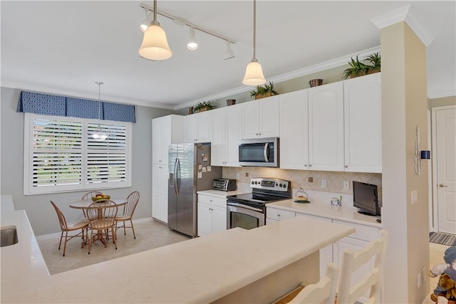 6341 Astor Pl, Vero Beach, FL 32966 - kitchen with appliances with stainless steel finishes, tasteful backsplash, rail lighting, light countertops, and hanging light fixtures
