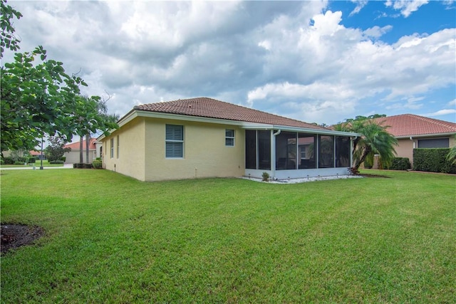 6341 Astor Pl, Vero Beach, FL 32966 - back of house with stucco siding, a yard, a sunroom, and a tile roof