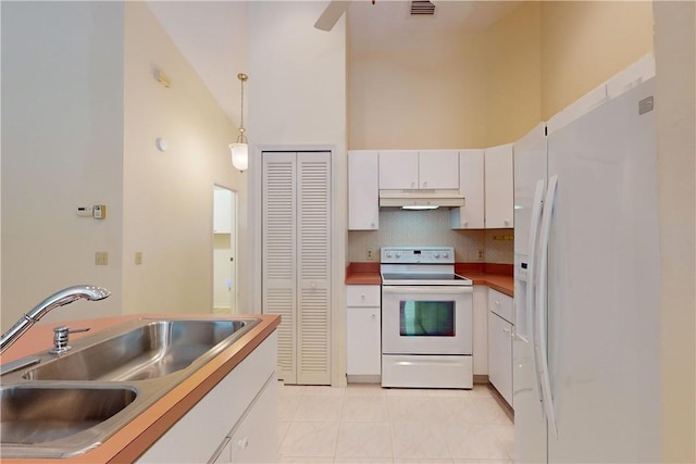 kitchen with pendant lighting, high vaulted ceiling, white cabinetry, sink, and white appliances