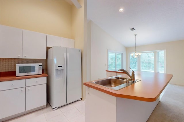 kitchen featuring pendant lighting, sink, white cabinets, a kitchen island with sink, and white appliances