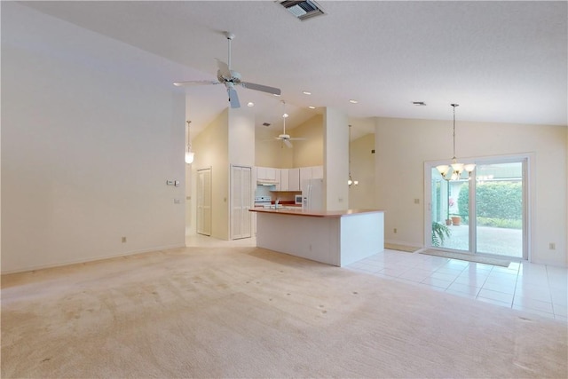 unfurnished living room with high vaulted ceiling, ceiling fan with notable chandelier, light colored carpet, and sink