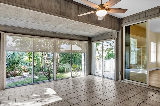 unfurnished sunroom with a wealth of natural light and ceiling fan