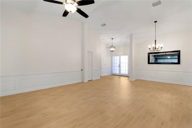 unfurnished living room with french doors, light hardwood / wood-style flooring, vaulted ceiling, and ceiling fan with notable chandelier