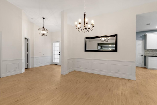 interior space with vaulted ceiling, light hardwood / wood-style floors, and an inviting chandelier