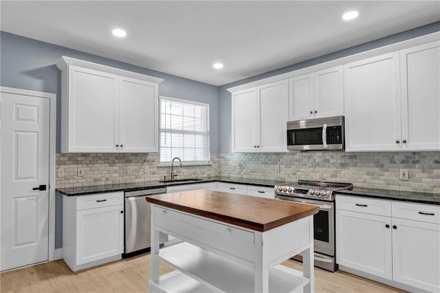 kitchen featuring backsplash, sink, white cabinets, and stainless steel appliances