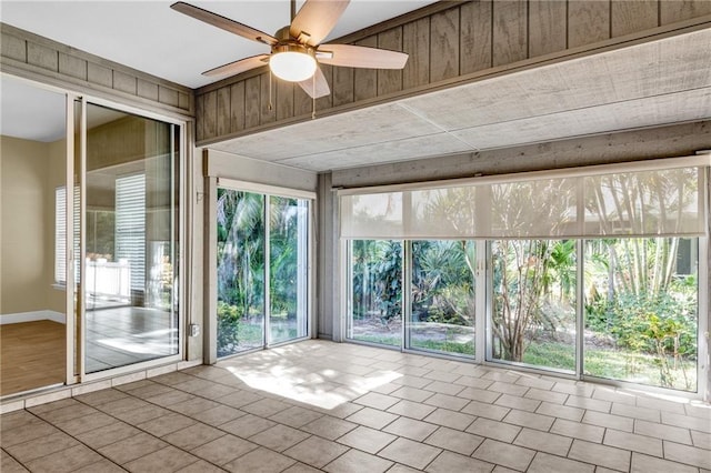 unfurnished sunroom with ceiling fan