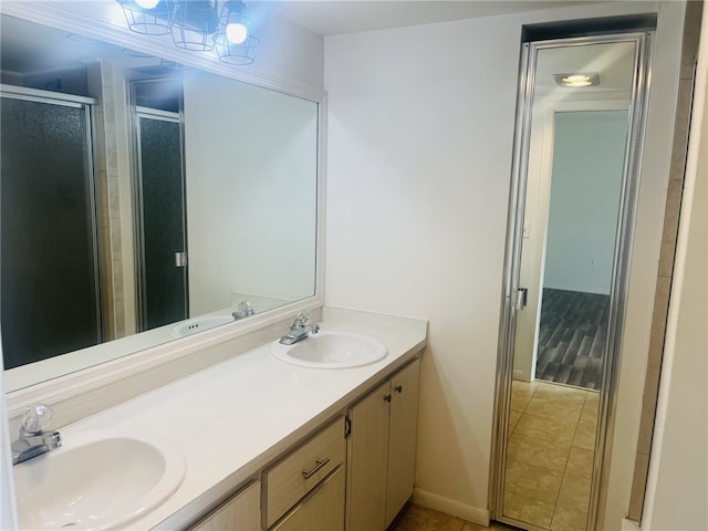 bathroom featuring tile patterned floors, vanity, and a shower with shower door