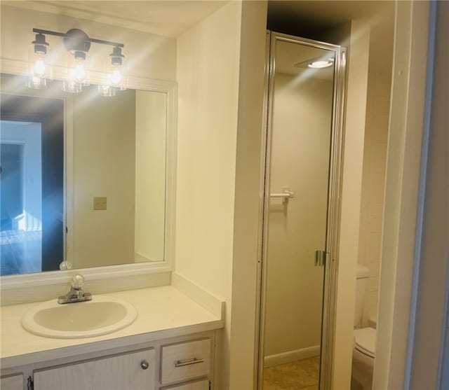 bathroom featuring tile patterned flooring, vanity, toilet, and an enclosed shower