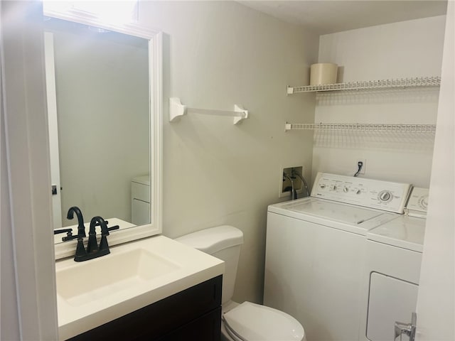 bathroom featuring washer and clothes dryer, vanity, and toilet