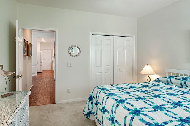 carpeted bedroom featuring a closet and white refrigerator