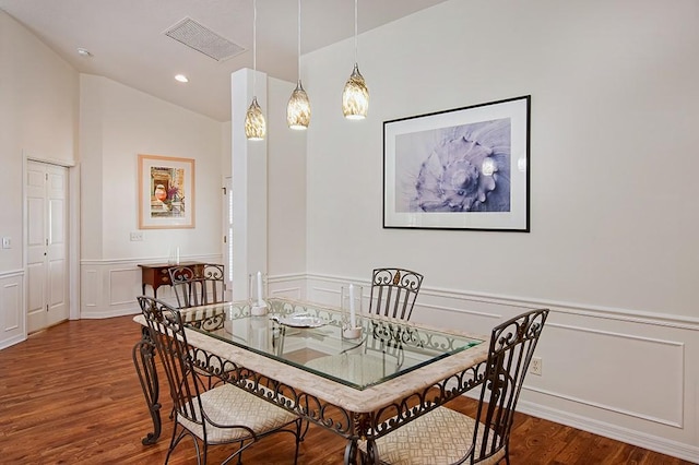 dining space featuring lofted ceiling and hardwood / wood-style flooring