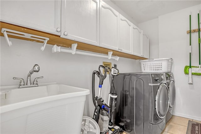 washroom featuring cabinets, light tile patterned flooring, washer and dryer, and sink