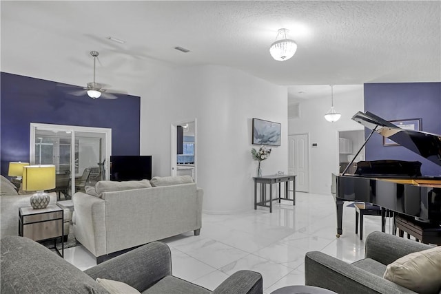 living room with ceiling fan and a textured ceiling