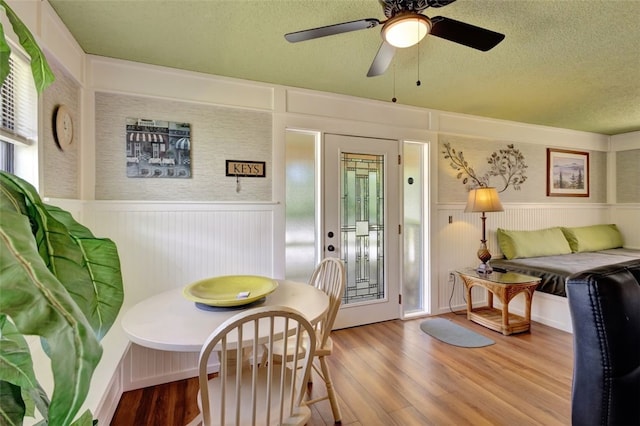 1805 15th St SW, Vero Beach, FL 32962 - dining space with a ceiling fan, wainscoting, a textured ceiling, and wood finished floors