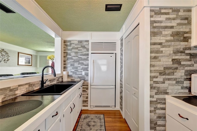 1805 15th St SW, Vero Beach, FL 32962 - kitchen with a sink, white refrigerator, a textured ceiling, and visible vents