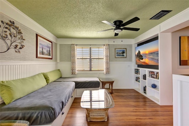 1805 15th St SW, Vero Beach, FL 32962 - living area with a wainscoted wall, a textured ceiling, visible vents, built in shelves, and ceiling fan