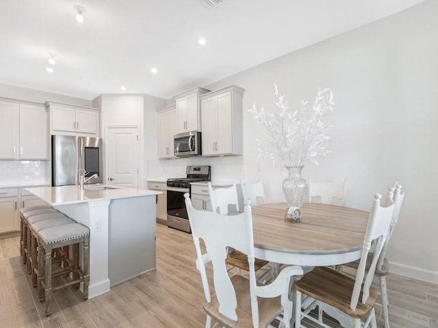 kitchen featuring light wood-style flooring, appliances with stainless steel finishes, and a sink