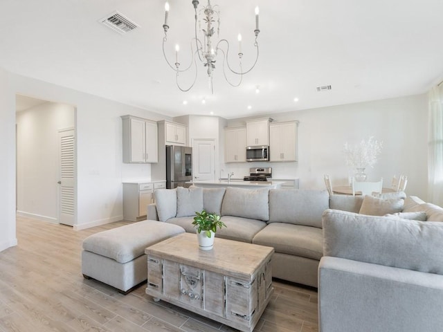 living room with light wood-style flooring, recessed lighting, visible vents, baseboards, and an inviting chandelier