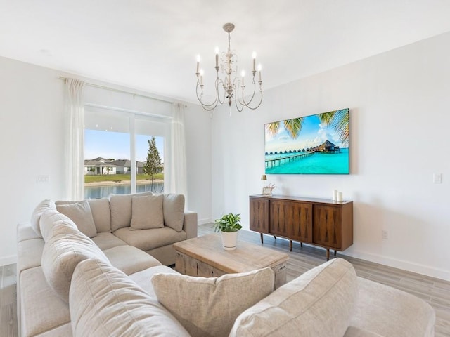 living room featuring a notable chandelier, baseboards, and wood finished floors