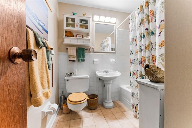 bathroom featuring toilet, tile patterned floors, shower / bathtub combination with curtain, and tile walls