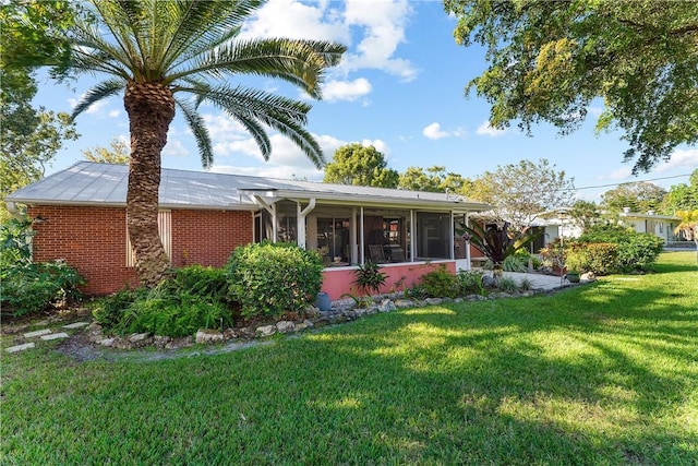 view of front facade featuring a front yard and a sunroom