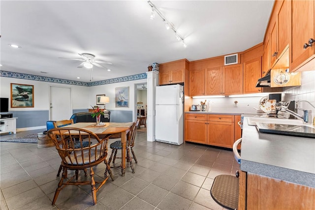 kitchen featuring backsplash, extractor fan, ceiling fan, tile patterned flooring, and white fridge