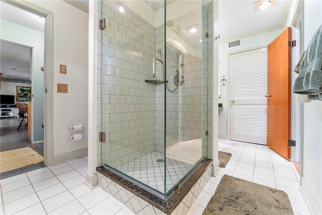 bathroom with tile patterned floors, crown molding, and walk in shower