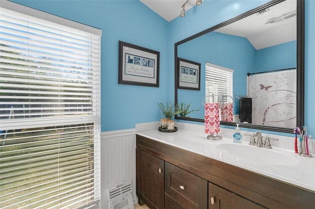 bathroom with vanity, vaulted ceiling, and walk in shower